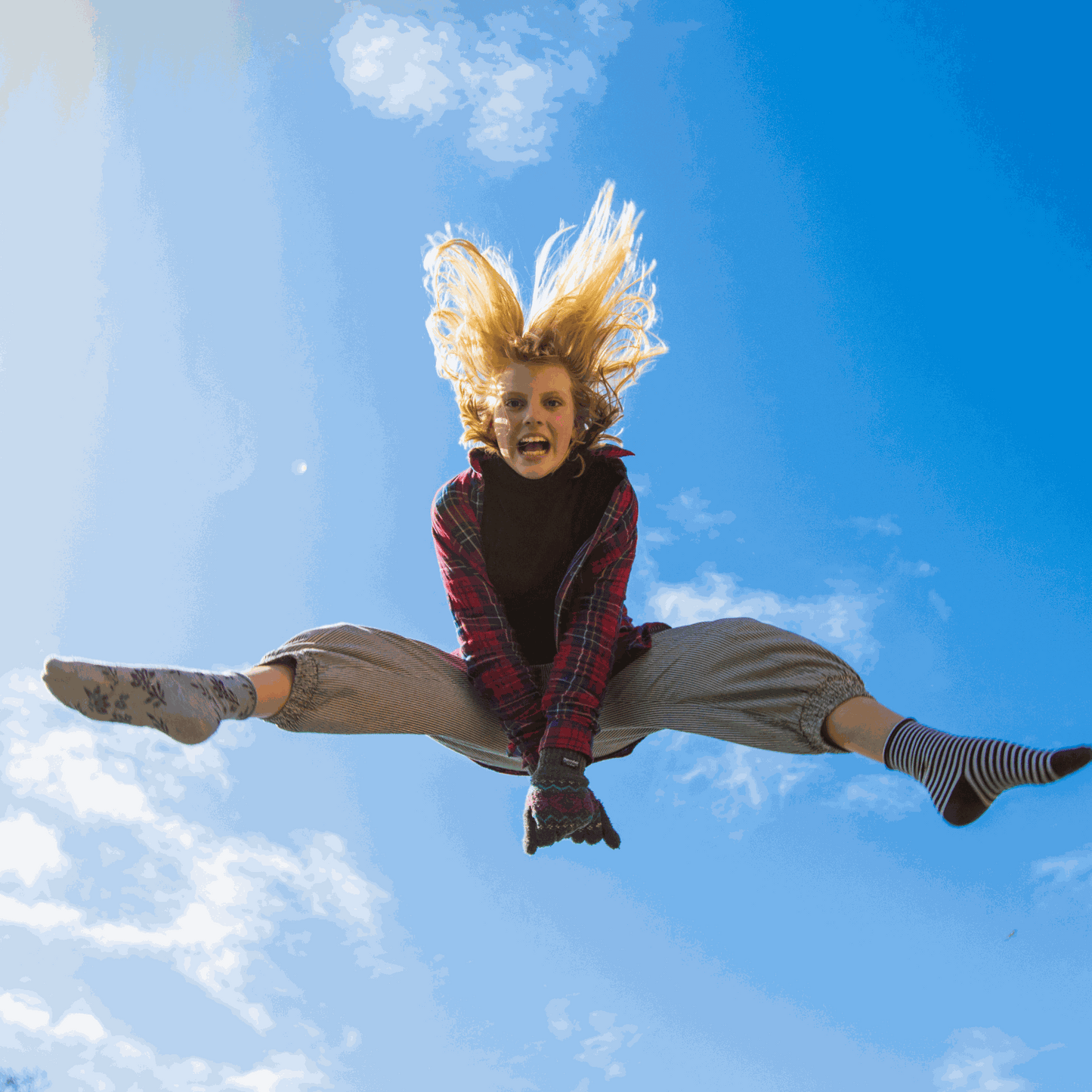 Energetic joyful person leaping high in blue sky symbolizing vitality of Witchy Pooh's Jack Rabbit Energy Tea