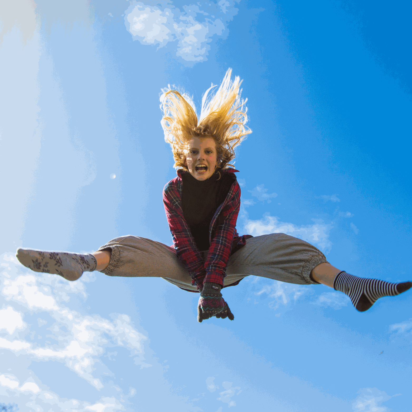 Energetic joyful person leaping high in blue sky symbolizing vitality of Witchy Pooh's Jack Rabbit Energy Tea